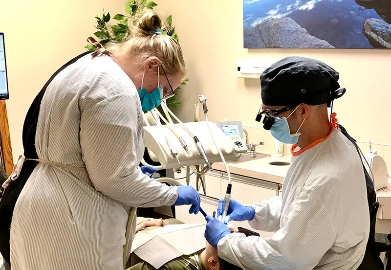 A dentist and assistant treating a patient at Ascent Family Dental